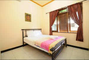 a bedroom with a bed and a window at Joyful Home in Yogyakarta