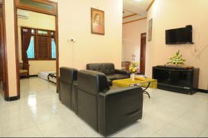 日惹的住宿－快樂之家度假屋，客厅配有椅子、沙发和电视