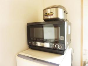 a toaster oven sitting on top of a microwave at Ocean Front Miyakojima in Miyako Island