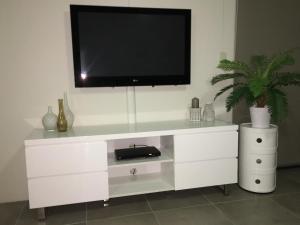 uma cómoda branca com uma televisão por cima em Linden Court Broadbeach em Gold Coast