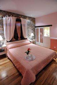 Un dormitorio con una cama grande con un plato. en Boutique Hotel Kentrikon & Bungalows, en Agios Ioannis