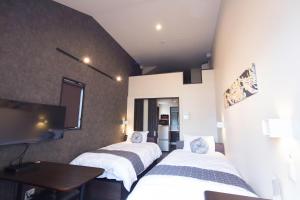 a room with three beds and a flat screen tv at Gion HANNA STAY in Kyoto +92 photos