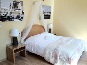 a bedroom with a bed and a table with lamps at Hôtel Du Théâtre Centre Historique - Parking Souterrain Public Gratuit in Metz