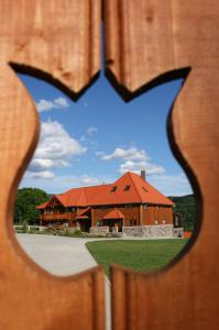 a building with a red roof viewed through a fence at Honor Villa in Izvoare