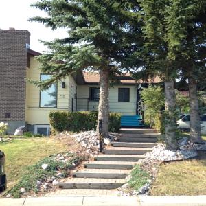 a house with trees and stairs in front of it at Calgary Star Cozy Home in Calgary