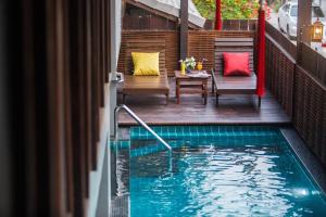 a swimming pool with a table and chairs on a balcony at Night Bazaar Inn in Chiang Mai