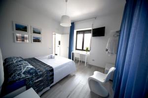 een slaapkamer met een bed, een stoel en een raam bij SOHO B&B in Fisciano