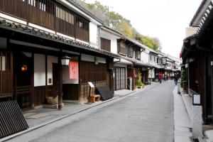 una calle vacía en un pueblo asiático con edificios en Yoshii Ryokan, en Kurashiki
