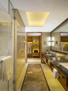 a bathroom with a shower and a sink and a mirror at Kunshan Jinling Hotel in Kunshan