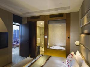 Postel nebo postele na pokoji v ubytování Kunshan Jinling Hotel