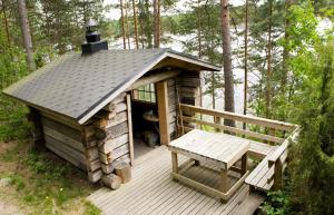 eine Blockhütte mit einer Bank auf einer Terrasse in der Unterkunft Tivoli Cottage in Talviainen