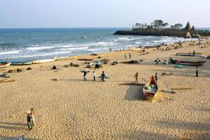 a group of people on a beach near the ocean at Arun Cottages in Mahabalipuram