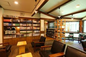 a library with chairs and tables and bookshelves at Nukumorino-yado Komanoyu in Kiso