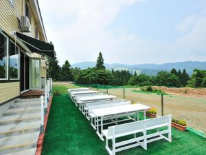 a row of white tables on the side of a building at Lodge B&W in Minami Uonuma