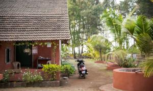 a motorcycle parked in front of a house at Samarth Atc-Beach Home Stay in Ratnagiri