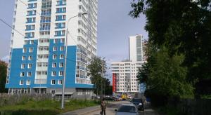 ペルミにあるStudio u Permskoy Yarmarkiの高層ビルの前に車を停めた街道