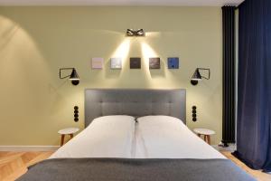 a bedroom with a bed with lights on the wall at INA Rent - Tre Mare Apartamenty in Gdańsk
