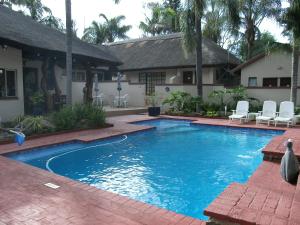 a swimming pool in front of a house at Marlot Guest House in Polokwane