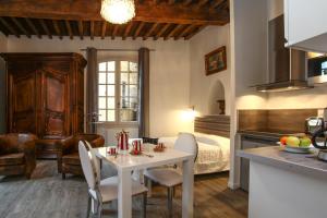 a kitchen and living room with a table and a bed at L'Alcove in Sarlat-la-Canéda +12 photos