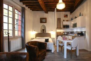 a bedroom with a bed and a table and chairs at L'Alcove in Sarlat-la-Canéda