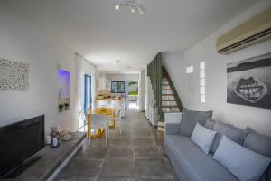 a living room with a gray couch and a television at Protaras Villa Loulla in Protaras