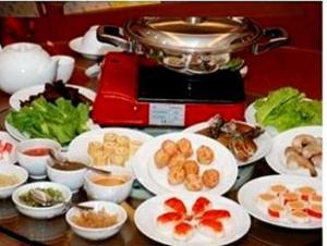una mesa con platos de comida y una tostadora roja en Abadi Suite Hotel & Tower, en Jambi