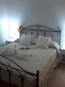 a bedroom with a bed with white sheets and pillows at La casa di Donato in Palinuro