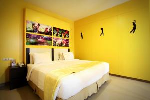 Un dormitorio con una cama y algunos cuadros en la pared. en Sinar Sport Hotel, en Bengkulu