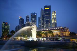 a water fountain in front of a city at night at The Fullerton Hotel Singapore in Singapore