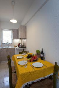a kitchen with a table with a yellow table cloth at Spathies in Kalogria