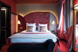 sypialnia z dużym łóżkiem z czerwonym zagłówkiem w obiekcie Maison Nabis by HappyCulture w Paryżu