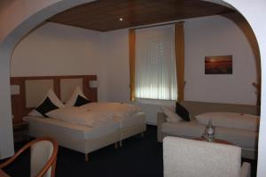 ein Schlafzimmer mit zwei Betten und einer Couch und einem Fenster in der Unterkunft Gasthof Tepferdt in Rees