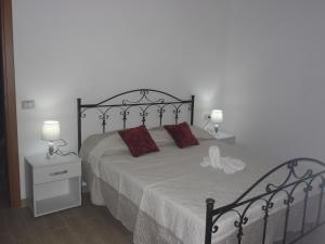 a bedroom with a bed with two red pillows at La casa di Donato in Palinuro +13 photos