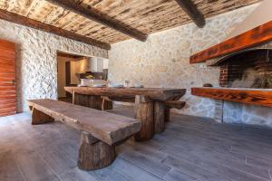 a kitchen with wooden benches and a fireplace at Villa Viktorija in Galovac