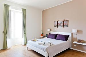 パレルモにあるLe Stanze di Federicoのベッドルーム(紫色の枕が付いた大きな白いベッド付)