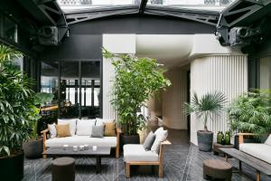 una hall con divani e piante in un edificio di Hôtel National Des Arts et Métiers a Parigi