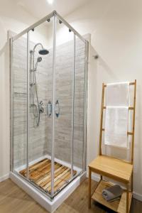 a shower with a glass enclosure next to a wooden chair at Le Stanze di Federico in Palermo