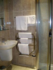 a bathroom with a shower and a sink and towels at Carousel Hotel in Blackpool