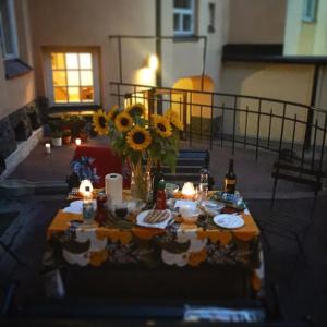 a table with a vase of sunflowers and candles at Artist Apartment Susi in Helsinki