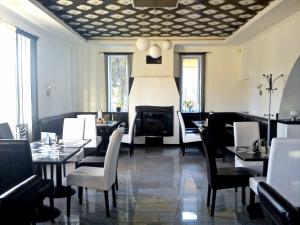 uma sala de jantar com mesas e cadeiras e uma lareira em OP-ART Étterem és Panzió em Monor