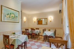 een restaurant met tafels en stoelen en een spiegel bij Hotel Silla in Rome