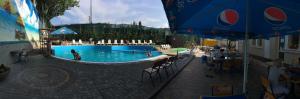 a large swimming pool with people in the water at Hotel Karavella Завжди є світло! in Mykolaiv