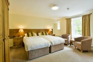 a hotel room with two beds and two lamps at Edenhall Country Hotel in Penrith