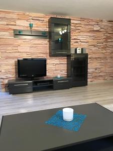 Una sala de estar con un televisor y una mesa. en Apartment Royal Bavaria, en Füssen