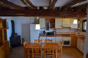 a kitchen with a table and chairs in a room at Can Sabate in Hospitalet de l'Infant