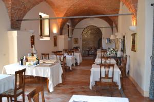 uma sala de jantar com mesas e cadeiras brancas em Agriturismo Montecorona em Umbertide