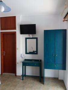 a room with a blue cabinet and a mirror at Galini Studios in Palaiochora
