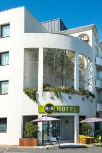 un bâtiment avec un panneau d'hôtel devant lui dans l'établissement B&B HOTEL La Rochelle Centre, à La Rochelle