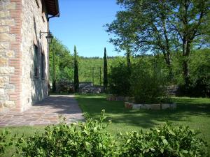 a garden with trees and a brick building at Le querce felici in Montegabbione