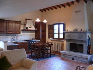 a kitchen with a fireplace and a table and chairs at Le querce felici in Montegabbione